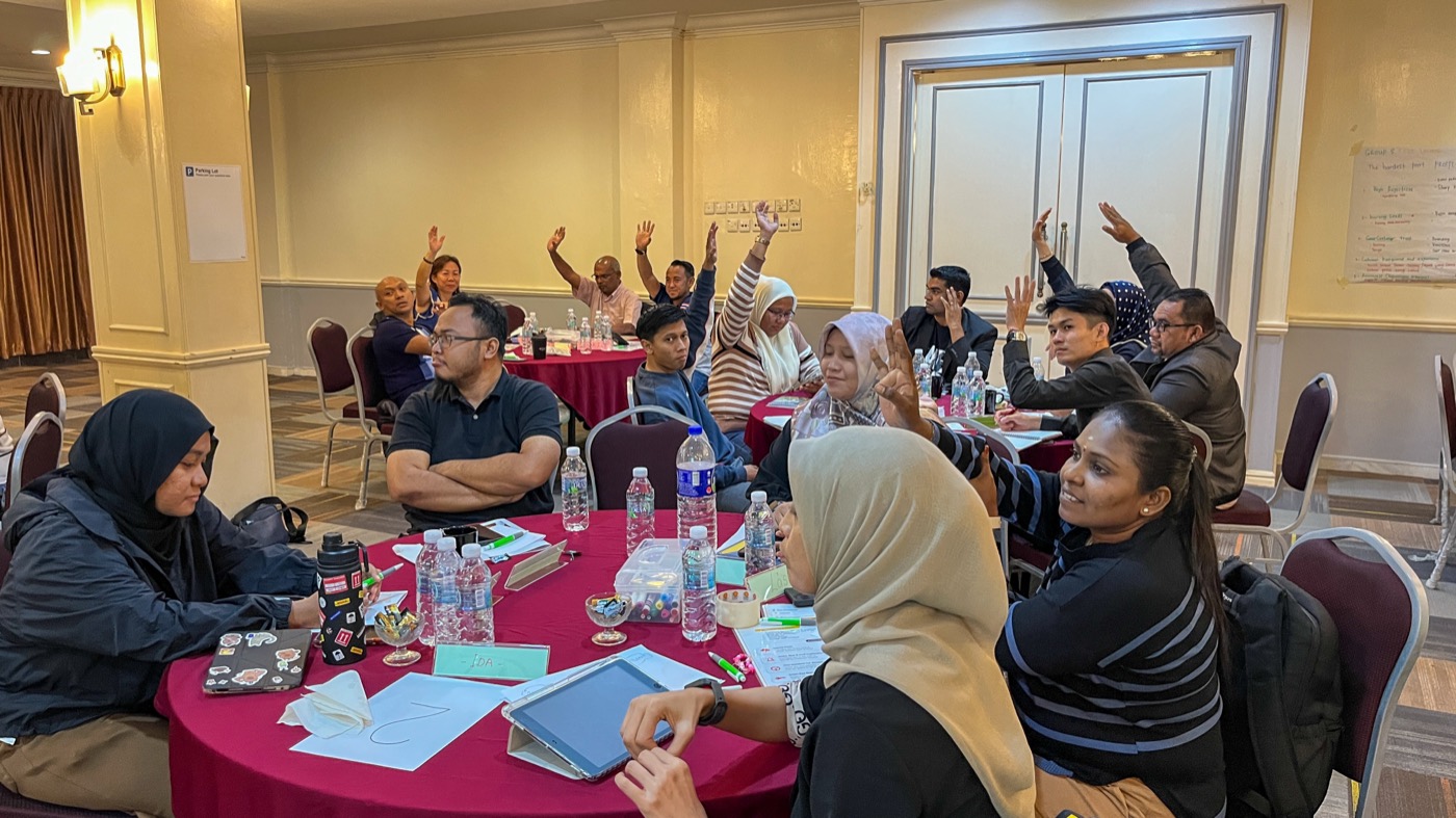 Participants raising their hands during a group discussion