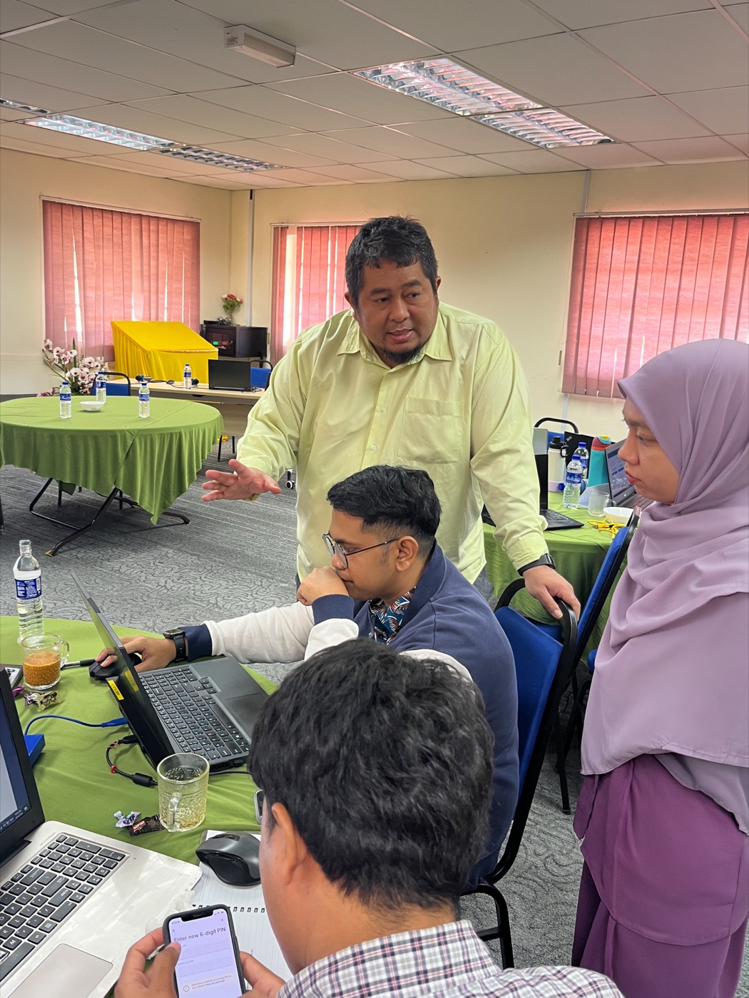 A trainer coaching participants at their laptop