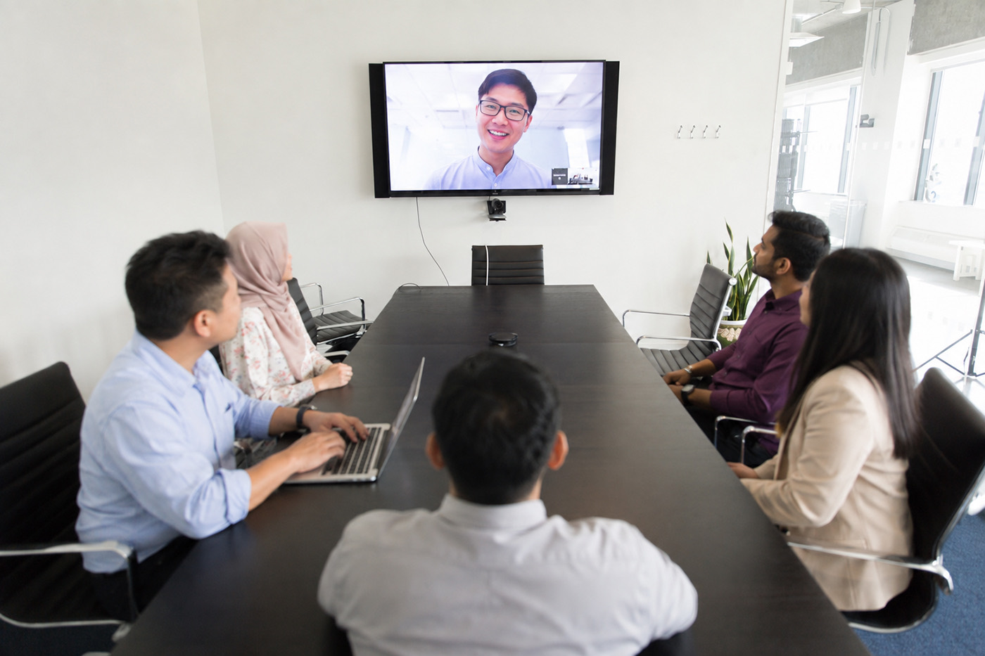 A team joining a live online session in a meeting room