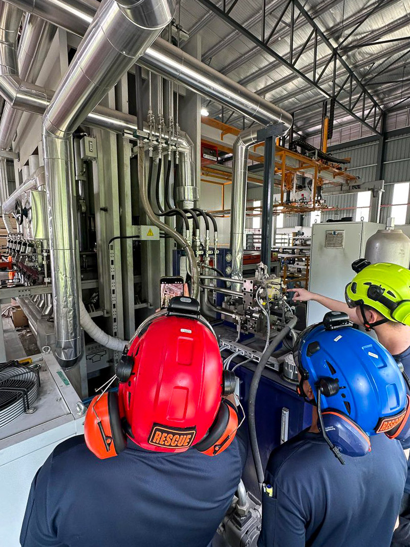 Rescue team inspecting industrial machinery in full safety gear