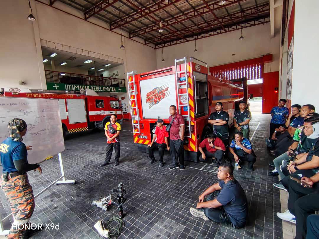 A trainer briefing a team beside a fire engine