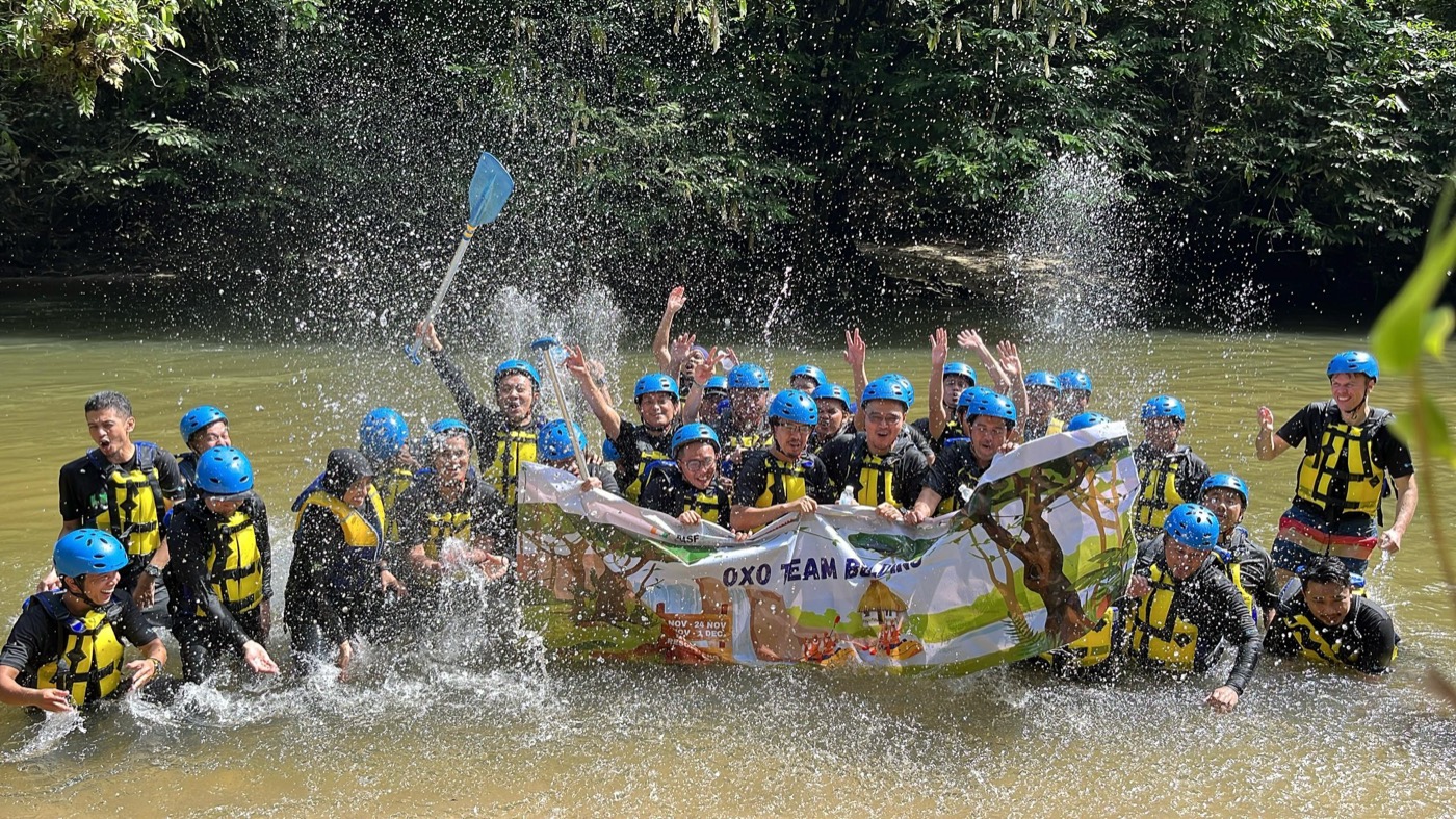 A team celebrating together in the river after a challenge