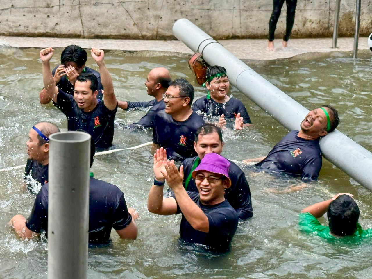 Colleagues laughing through a water obstacle challenge