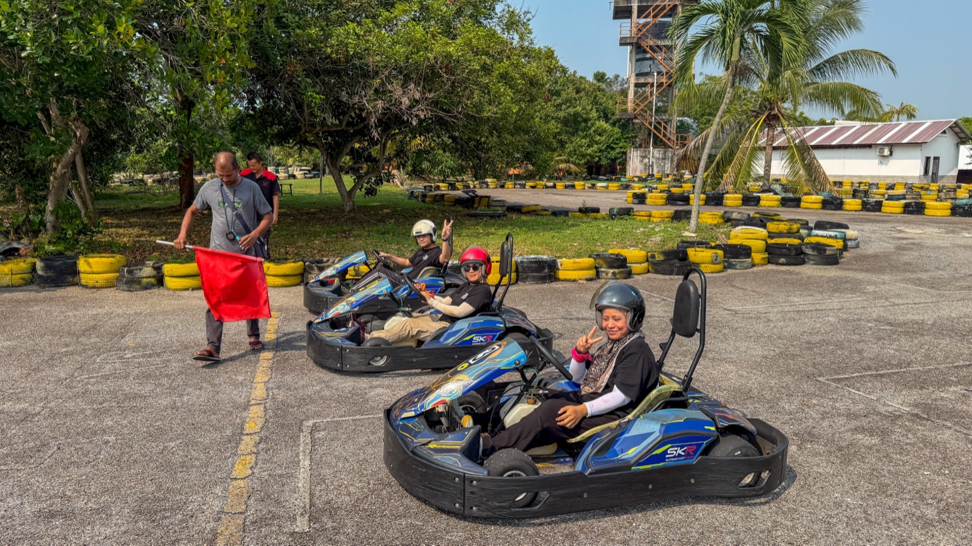 Colleagues racing go-karts together